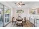 Cozy dining area with a glass-top table, sliding glass door, and adjacent kitchen bar at 7680 Depew St # 1404, Arvada, CO 80003