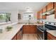 Efficient kitchen with wood cabinets, stainless steel oven and sink with views of the neighborhood at 7680 Depew St # 1404, Arvada, CO 80003