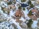 Stunning aerial view of a home with a sprawling lot and mature trees in a snow-covered landscape at 10895 Pheasant Run, Littleton, CO 80125