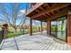 A spacious back deck is attached to the house with metal railings, wood floors, and sliding glass door at 10895 Pheasant Run, Littleton, CO 80125