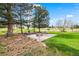 Landscaped backyard with a brick paved patio with outdoor seating, a stone fire pit, and mature trees at 10895 Pheasant Run, Littleton, CO 80125