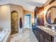 Bathroom with granite countertops, dark cabinets, a shower, and a soaking tub at 10895 Pheasant Run, Littleton, CO 80125