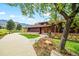 Charming home featuring wood siding, stone accents, and a tile roof surrounded by mature landscaping at 10895 Pheasant Run, Littleton, CO 80125