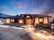 Charming home at twilight features a stone facade, wood siding, and a welcoming front entrance at 10895 Pheasant Run, Littleton, CO 80125