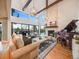 Bright living room with vaulted ceilings, wood beams, floor-to-ceiling windows, fireplace, and grand piano at 10895 Pheasant Run, Littleton, CO 80125