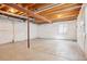 Unfinished basement with concrete floor and exposed wood ceiling beams, offering potential for customization at 1557 S Dallas Cir, Denver, CO 80247