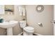 Cozy half bathroom featuring a pedestal sink, decorative mirror, and neutral walls at 1557 S Dallas Cir, Denver, CO 80247