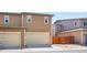 Townhome exterior shows a two-car garage, a low-maintenance rock patch, and a privacy fence at 1557 S Dallas Cir, Denver, CO 80247