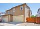Townhome exterior features a two-car garage and low-maintenance landscaping at 1557 S Dallas Cir, Denver, CO 80247