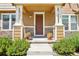 Inviting front porch with classic columns, stone accents, and manicured landscaping, creating curb appeal at 1557 S Dallas Cir, Denver, CO 80247