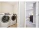 Bright laundry room with modern washer and dryer, leading into a stylish bedroom with neutral tones at 1557 S Dallas Cir, Denver, CO 80247