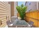 Back patio area features a glass table with chairs with a cozy rug and wood fencing at 1557 S Dallas Cir, Denver, CO 80247