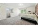 Bright bedroom featuring plush carpeting, a comfortable bed, and adjacent bathroom at 1341 S Blackhawk Way, Aurora, CO 80012