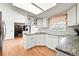 Bright kitchen with white cabinets, granite countertops, and stainless steel appliances at 1341 S Blackhawk Way, Aurora, CO 80012
