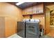 This laundry room features a washer and dryer with wooden cabinets above at 1341 S Blackhawk Way, Aurora, CO 80012