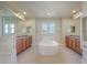 Bright bathroom with dual sinks, corner tub, and glass enclosed shower with bright windows at 10003 Atlanta St, Parker, CO 80134