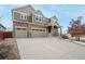 Beautiful home with a large driveway, three-car garage, stone accents, and professionally landscaped yard at 10003 Atlanta St, Parker, CO 80134