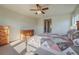 Bright bedroom featuring a patterned quilt, wooden dressers, and a ceiling fan with light fixture at 10003 Atlanta St, Parker, CO 80134