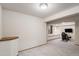 A carpeted basement with a recessed seating area and a gaming chair at 11418 W Roxbury Ave, Littleton, CO 80127