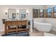 Bright bathroom featuring double sinks, a modern soaking tub, wood accents, and contemporary fixtures at 11418 W Roxbury Ave, Littleton, CO 80127