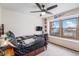 Comfortable bedroom featuring a dark wood bed, a fan, and a window at 11418 W Roxbury Ave, Littleton, CO 80127