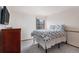 Simple bedroom featuring neutral carpet, a white bedspread, and a dark dresser at 11418 W Roxbury Ave, Littleton, CO 80127