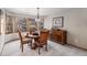 Inviting dining room with a round table, four chairs, a dark wood buffet, and ample natural light from surrounding windows at 11418 W Roxbury Ave, Littleton, CO 80127