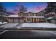 Charming two-story home boasting a three-car garage and attractive brick accents, all beneath a colorful twilight sky at 11418 W Roxbury Ave, Littleton, CO 80127