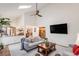 Bright and airy living room featuring a vaulted ceiling, a comfortable sofa, and an open view into the kitchen at 11418 W Roxbury Ave, Littleton, CO 80127