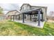 Backyard featuring a concrete patio with pergolas, a dining table, and a grill, with a well-manicured lawn at 11801 E 118Th Ave, Commerce City, CO 80640