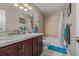 Well-lit bathroom featuring a double sink vanity, tiled shower/tub, and modern fixtures at 11801 E 118Th Ave, Commerce City, CO 80640
