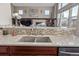 Modern kitchen sink with stainless steel faucet, granite countertops, and mosaic tile backsplash at 11801 E 118Th Ave, Commerce City, CO 80640