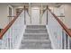 Carpeted staircase with wooden handrails and white balusters leading to the upper level at 11801 E 118Th Ave, Commerce City, CO 80640
