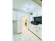 Well-lit kitchen featuring white cabinets and a view into the dining room at 3231 S Galapago St, Englewood, CO 80110