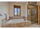 Beautifully designed bathroom with a soaking tub, a shower with glass doors, and a large window to bring in natural light at 330 N Rocky Cliff Trl, Franktown, CO 80016
