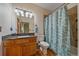 Traditional bathroom with granite vanity, toilet, and a shower/tub combo with blue floral curtain and wood plank flooring at 330 N Rocky Cliff Trl, Franktown, CO 80016