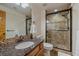 Updated bathroom featuring a granite countertop, modern shower with glass door and tiled walls at 330 N Rocky Cliff Trl, Franktown, CO 80016