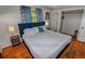 Bedroom with hardwood floors, blue curtains, tufted headboard and view of an open closet at 3071 S Jasmine St, Denver, CO 80222