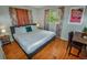 Bedroom featuring a cozy bed, study desk and a window with leafy view at 3071 S Jasmine St, Denver, CO 80222