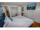 Bedroom featuring hardwood floors, a wall mounted TV, and an open closet at 3071 S Jasmine St, Denver, CO 80222