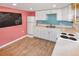 Basement kitchenette with white cabinets and blue tile backsplash at 3071 S Jasmine St, Denver, CO 80222
