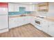 Basement kitchenette with white cabinets, blue backsplash, and tile floors at 3071 S Jasmine St, Denver, CO 80222