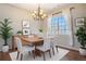 Bright dining room with hardwood floors, chandelier, and a large window with sheer curtains at 21710 Silver Meadow Ln, Parker, CO 80138