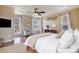 A bright main bedroom featuring hardwood floors, large windows, ceiling fan, and neutral decor at 21710 Silver Meadow Ln, Parker, CO 80138