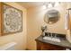 Bathroom featuring granite vanity, round mirror, and decorative wall art at 37677 Sable Ridge Rd, Elizabeth, CO 80107