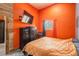 This bedroom features orange walls, two large gun safes, a window, and a television at 37677 Sable Ridge Rd, Elizabeth, CO 80107