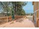 A wooden deck featuring wooden railing, an umbrella for shade, and views of the large backyard area at 37677 Sable Ridge Rd, Elizabeth, CO 80107