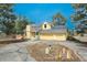 A sunny two-story home features a two car garage, solar panels, a covered front porch, and mature trees at 37677 Sable Ridge Rd, Elizabeth, CO 80107