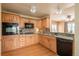 Well-lit kitchen features wooden cabinets, a black oven and microwave, a backsplash, and a stainless steel sink at 37677 Sable Ridge Rd, Elizabeth, CO 80107
