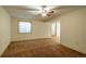 Spacious living room with carpeted floors, a ceiling fan, neutral walls, and a large opening to another room at 37677 Sable Ridge Rd, Elizabeth, CO 80107